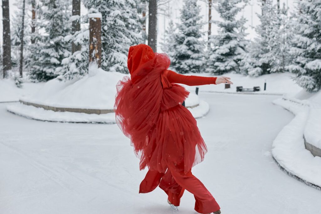 Frau in einem roten Kleid beim Eiskunstlaufen